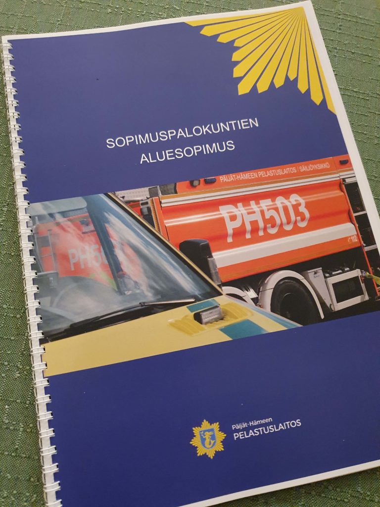 Sinikantinen vihko, jossa kuva paloautosta ja ambulanssista. Teksti sopimuspalokuntien aluesopimus.